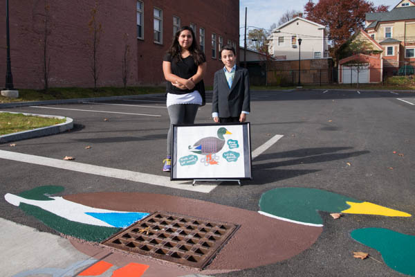 Holyoke student artists, Ariana Scribner and Issac Aponte pose with their storm drain art.