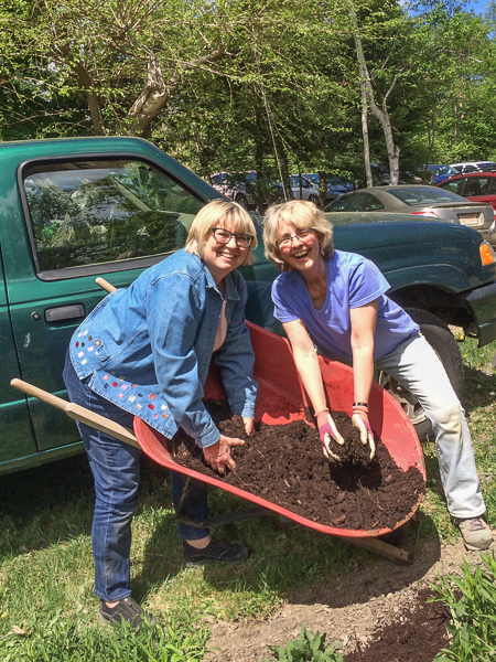 Linda Smith and Kathi Bangert distribute mulch in the gardens.