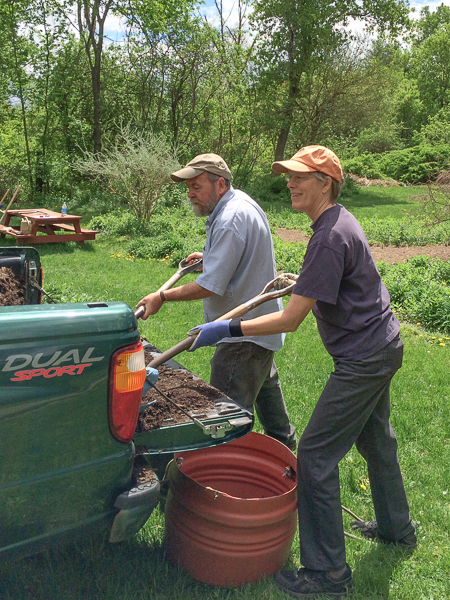 Ed Geaughan and Bridgit Litchfield move mulch.